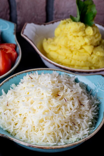 Plates of rice and mashed potatoes served with fresh salad