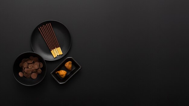 Plates with chocolate sticks on a dark background