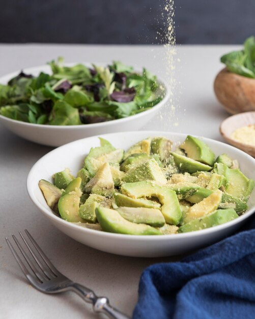 Plates with salad and avocado slices