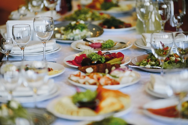 Тарелки с разнообразной едой на праздничном столе