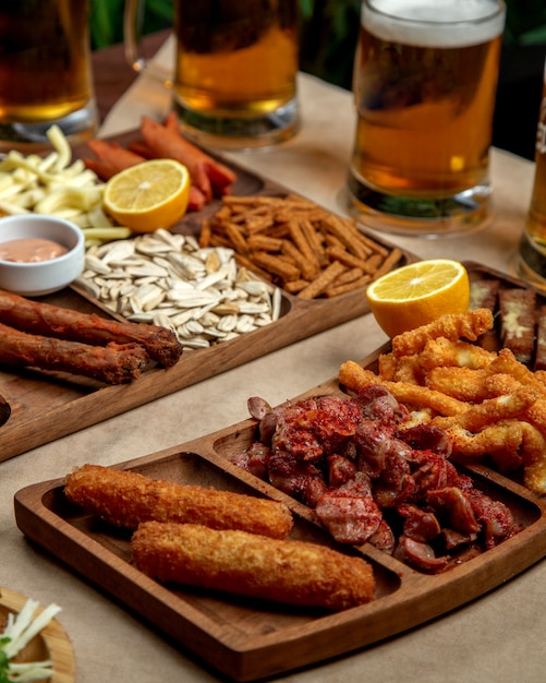 Platter of beer snacks with fried cheese chicken and sausages