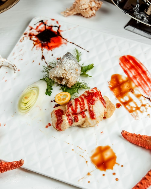 A platter of fried fish served with kumquat and herbs