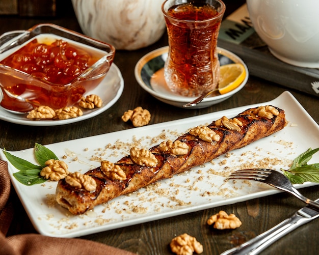 A platter of lula kebab topped with walnut