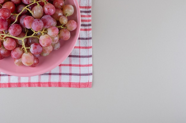 Бесплатное фото Блюдо с виноградом на полотенце на мраморе