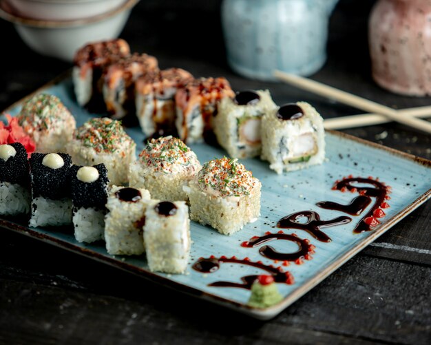 A platter of sushi rolls with salmon black tobiko tempura