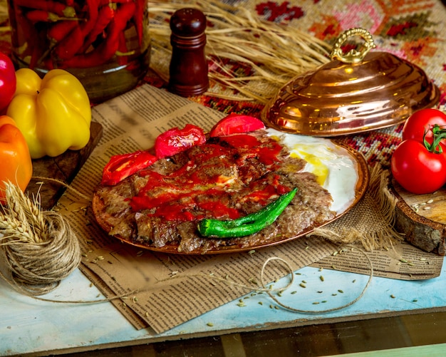 A platter of turkish lamb kebab served with yogurt grilled tomato and pepper