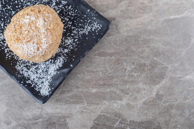 Platter with a flaky cookie on marble surface