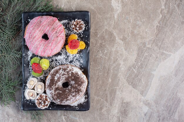 Platter with lokums, donuts, pine cones and marmelades on marble. 