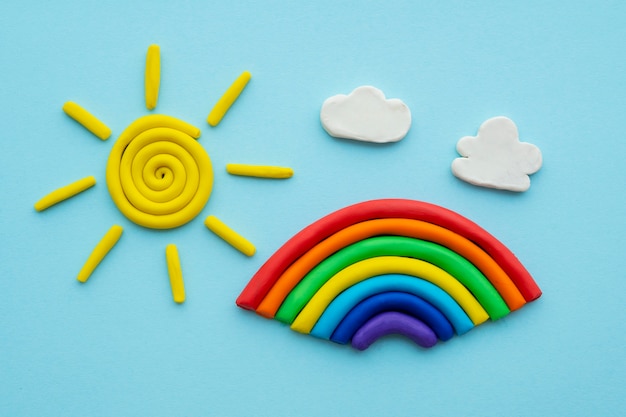 Foto gratuita gioca a sfondo di pasta con arcobaleno e sole