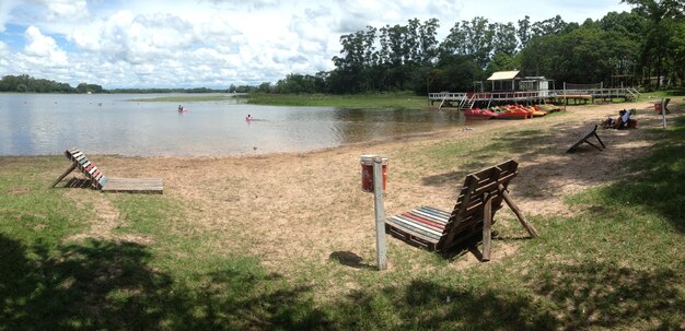 Playa Laguna beach surrounded by the lake and greenery under a cloudy sky in Argentina