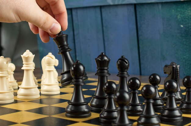 A player playing black figures on chessboard