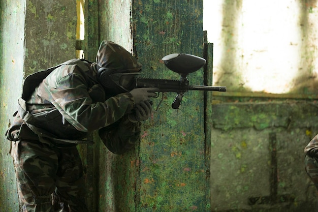 A player playing paintball game with a gun. High quality photo