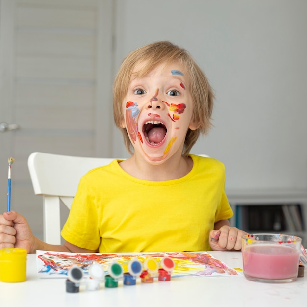 Free photo playful boy painting