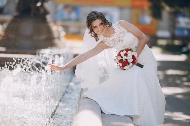 Playful bride having fun in the fountain