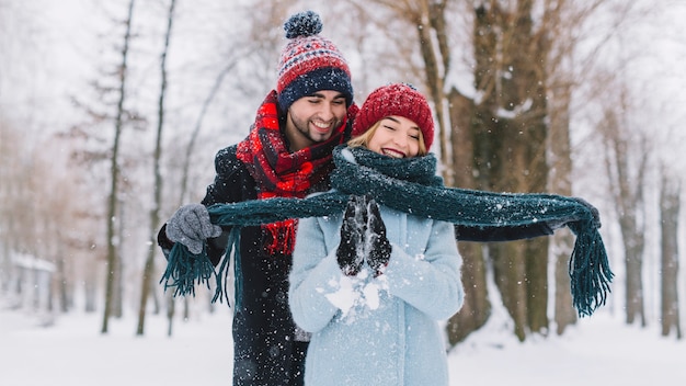 Playful cheerful couple in winter forest