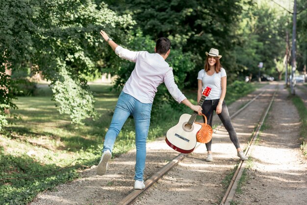 遊び心のあるカップルが鉄道の上を歩く