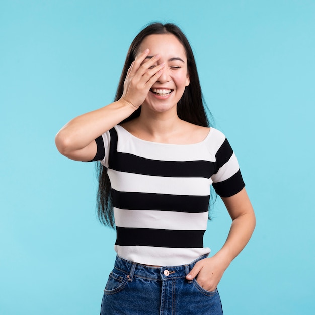 Playful female covering eye with hand