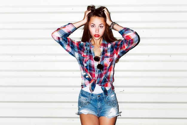 Playful girl with plaid shirt and hands on head