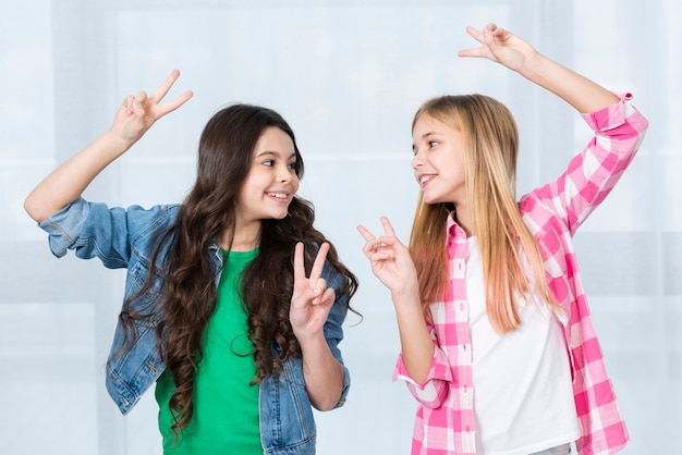 Ragazze allegre che mostrano il segno di pace