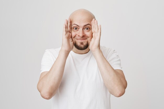 Free photo playful happy bald guy playing peekaboo