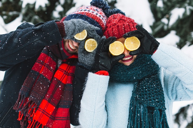 Playful laughing couple with lemons halves