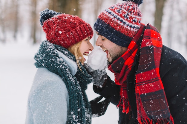 遊び心のある男と女の雪を食べる