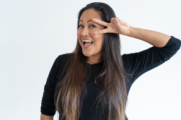 Playful middle-aged woman showing victory sign