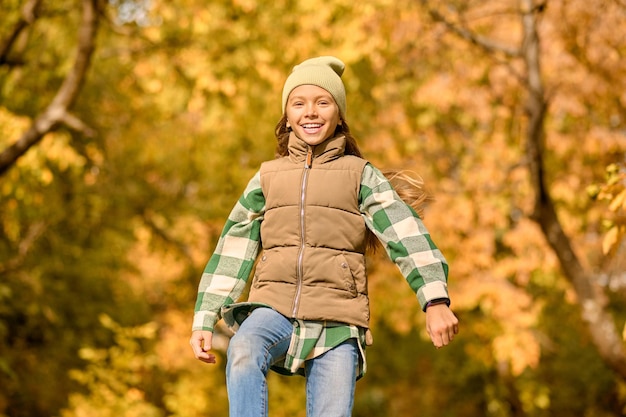 Free photo playful mood. a girl in warm clothes playing in the park