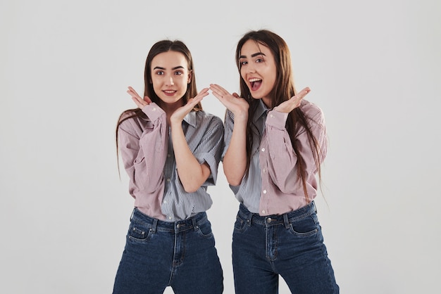Бесплатное фото Игривое настроение две сестры-близнецы стоят и позируют