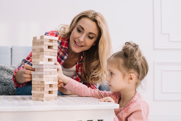 Playful mother and daughter in living room