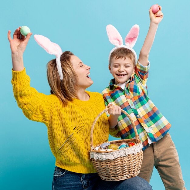 Playful mother and son showing painted eggs