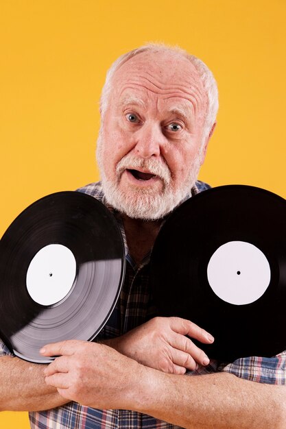 Playful senior holding music records