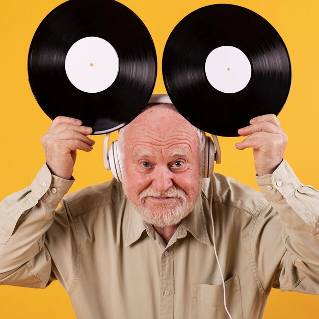 Playful senior holding music records