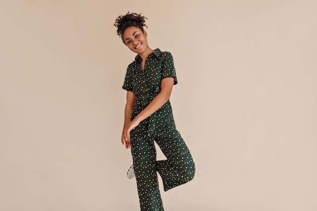 Playful woman posing in green overalls