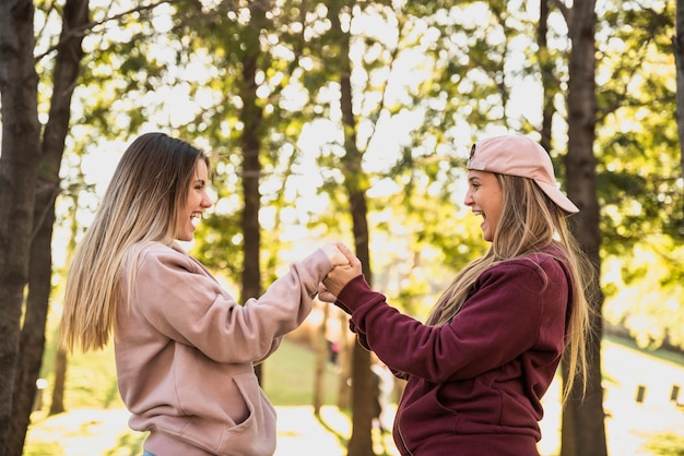 Free photo playful women holding each other hands