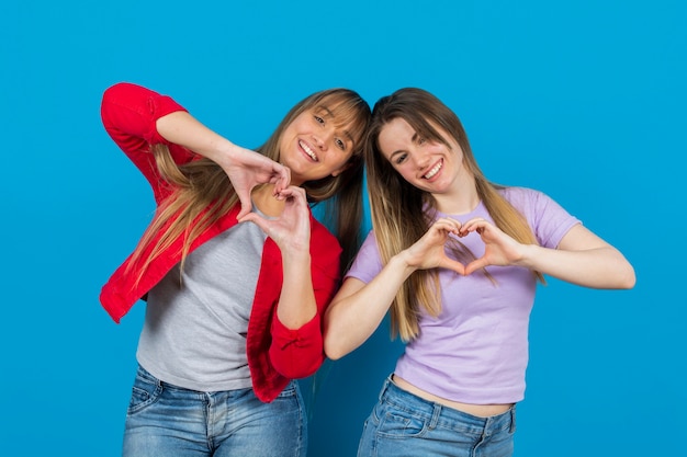Free photo playful women with hands in heart shape
