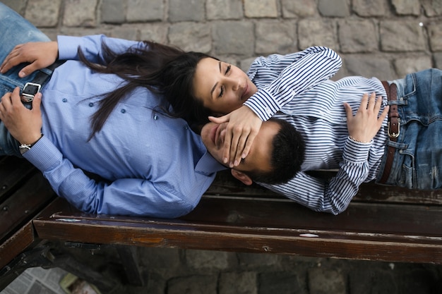 Playful young couple on bench