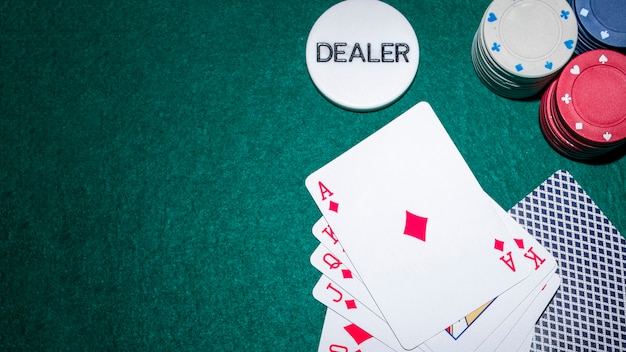 Playing cards and casino chips on green background