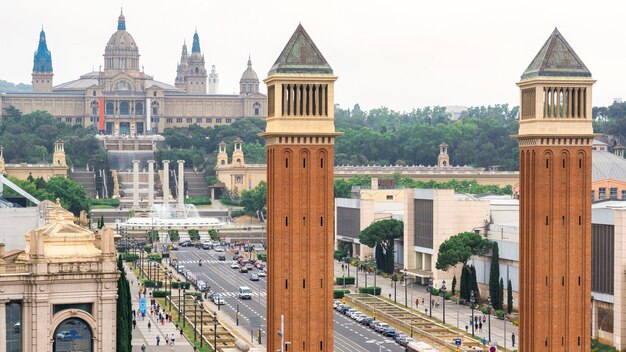 스페인 바르셀로나의 에스파냐 광장(Plaza de Espana), 베네치아 타워(Venetian Towers), 팔라우 나시오날(Palau Nacional). 흐린 하늘, 교통