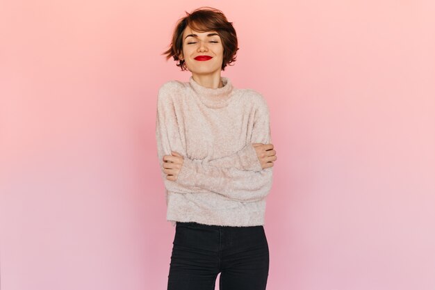 Pleasant woman in sweater posing with closed eyes