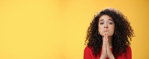 Free photo please i beg you portrait of sad and cute curlyhaired girl with angel eyes pouting holding hands in