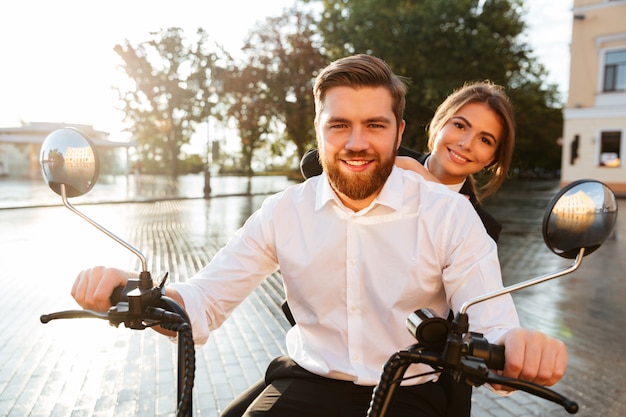 Coppia felice di affari guida su una moderna moto all'aperto