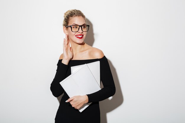 Pleased business woman in dress and eyeglasses holding documents