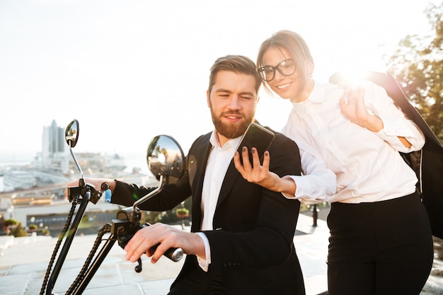 Pleased business woman standing near bearded man in suit