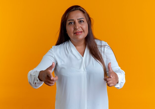 pleased casual caucasian middle-aged woman showing you gesture isolated on yellow