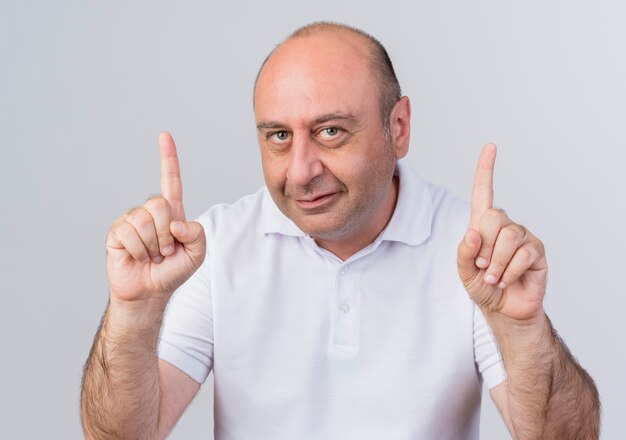 Pleased casual mature businessman looking at camera and raising fingers isolated on white background