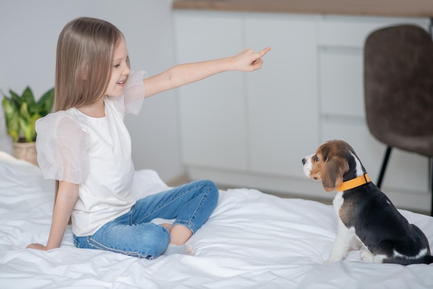 Felice bambina che pratica un nuovo comando con un cucciolo