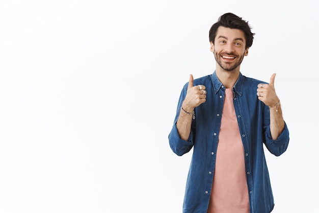 Pleased, friendly handsome caucasian man in casual outfit showing thumbs-up as rate something good, smiling and nod in agreement, give positive feedback, thinking something is excellent