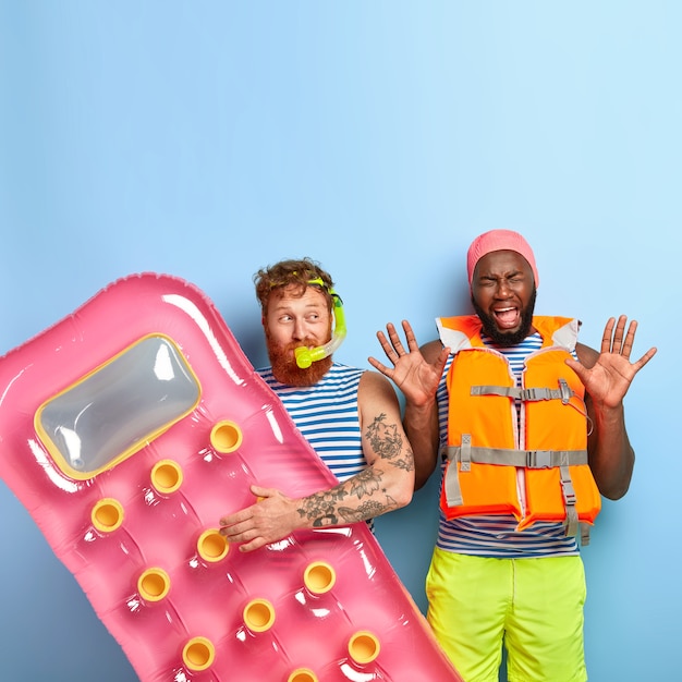 Free photo pleased friends posing with beach items