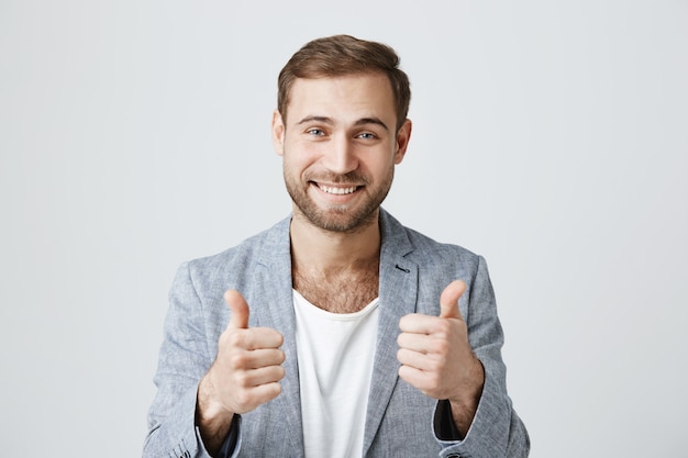 Pleased handsome male customer show thumb-up in approval